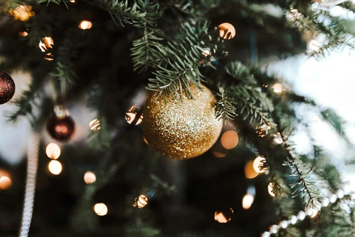 Weihnachten, Weihnachtsbaum, Zweig mit Lichtern und goldener Weihnachtskugel