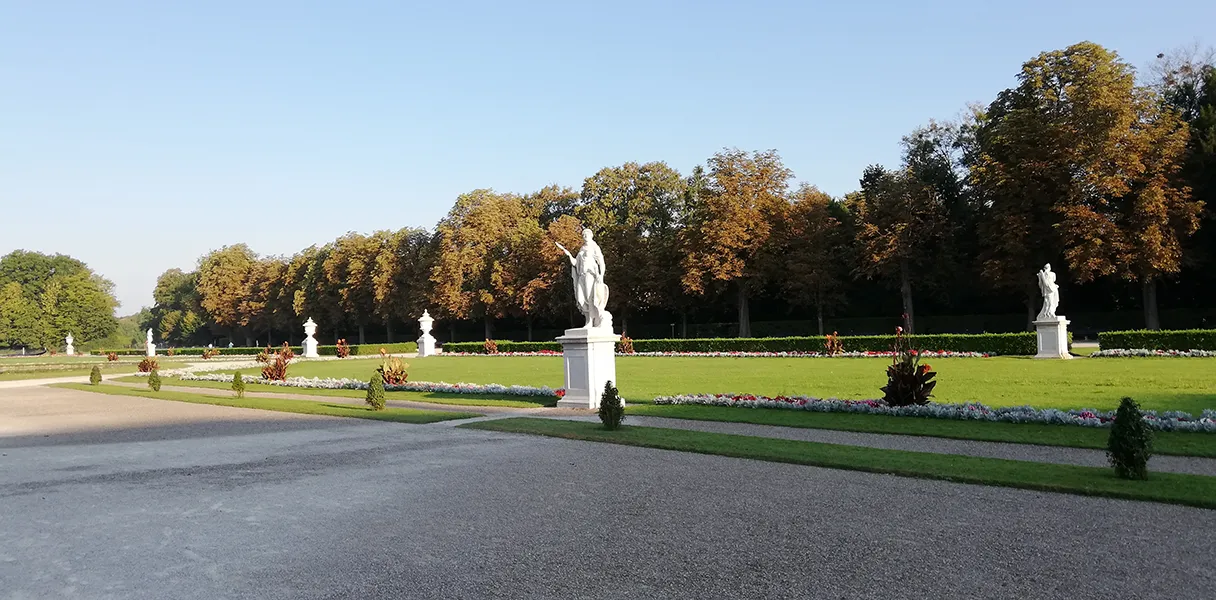 Schloss Nymphenburg München, Parkanlage, weiße Skulpturen stehen auf grünem Rasen