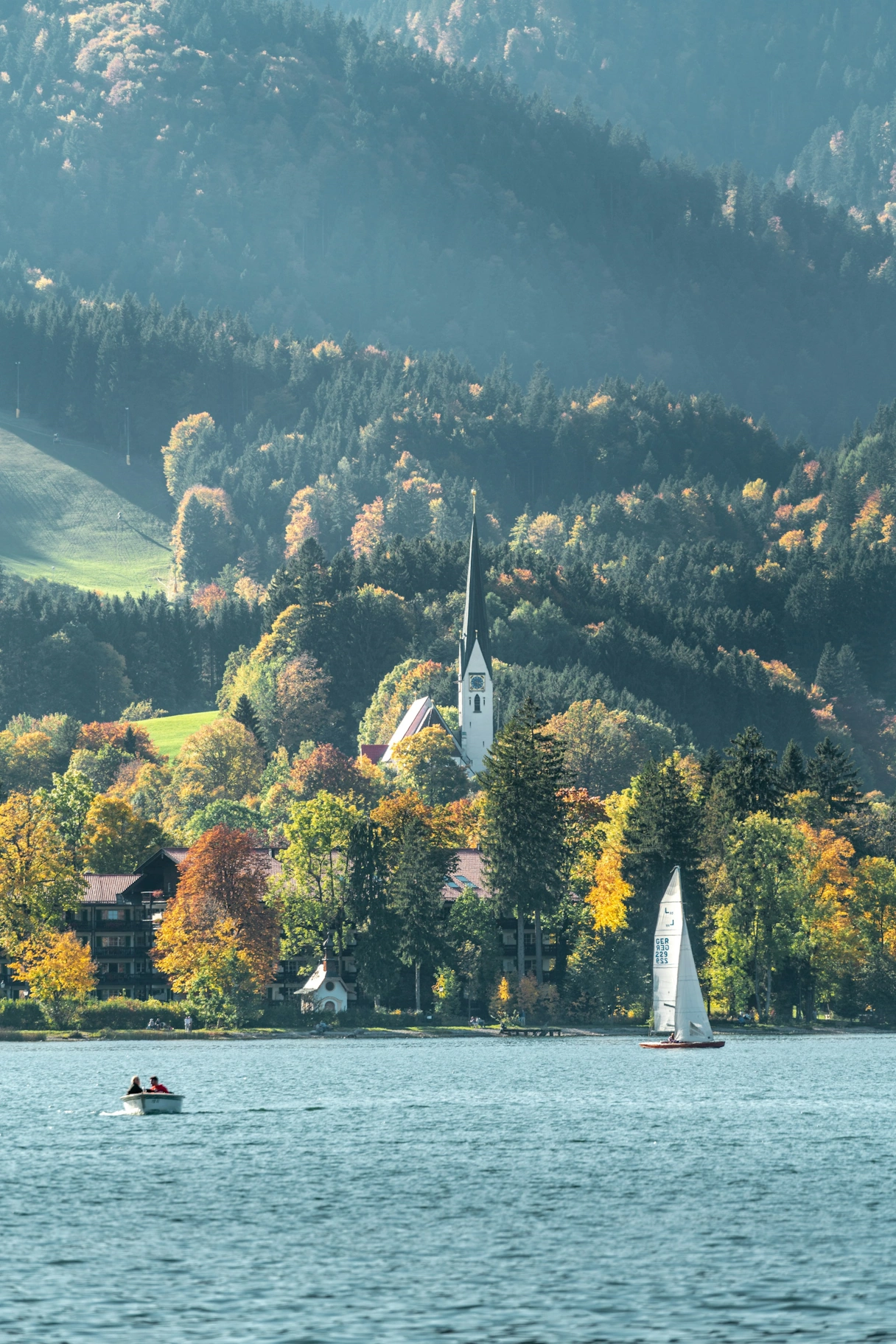 View of Lake Tegernsee with boats and forest in the background