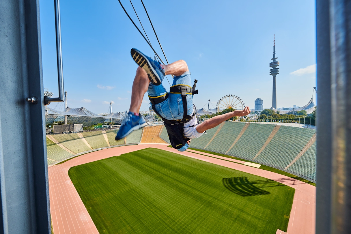 Sprung eines jungen Mannes durch das Olympiastadion an einem Seil