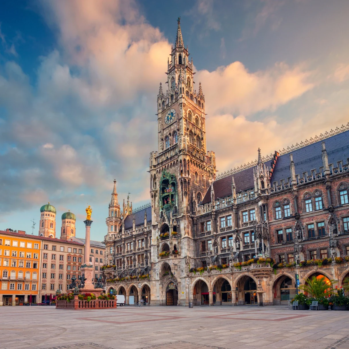 Bild vom Marienplatz in München. Es sind keine Menschen zu sehen. Blickrichtung: Neues Rathaus sowie Türme der Frauenkirche