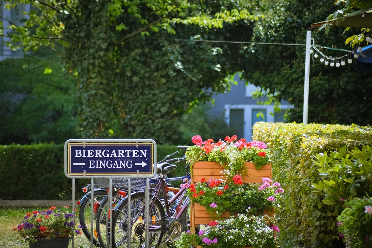 Biergarten, Eingangsbereich, Fahrräder stehen im Fahrradständeer, grüne Hecke