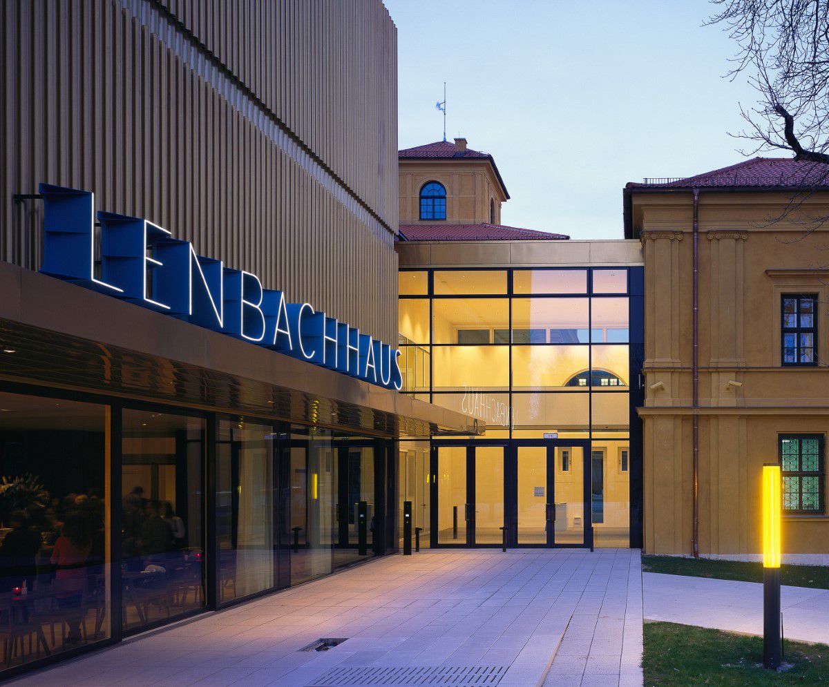 Lenbachhaus Außenaufnahme, Eingangsbereich, gelbes Licht leuchtet durch den gläsernen Eingangsbereich