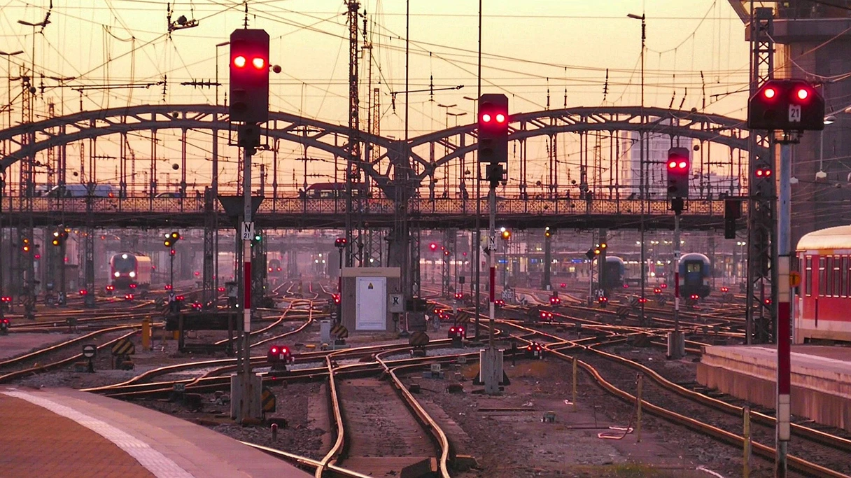 Bahnhof München, Sonnenuntergang, Gleise, rote Ampeln, die den Zugverkehr regeln