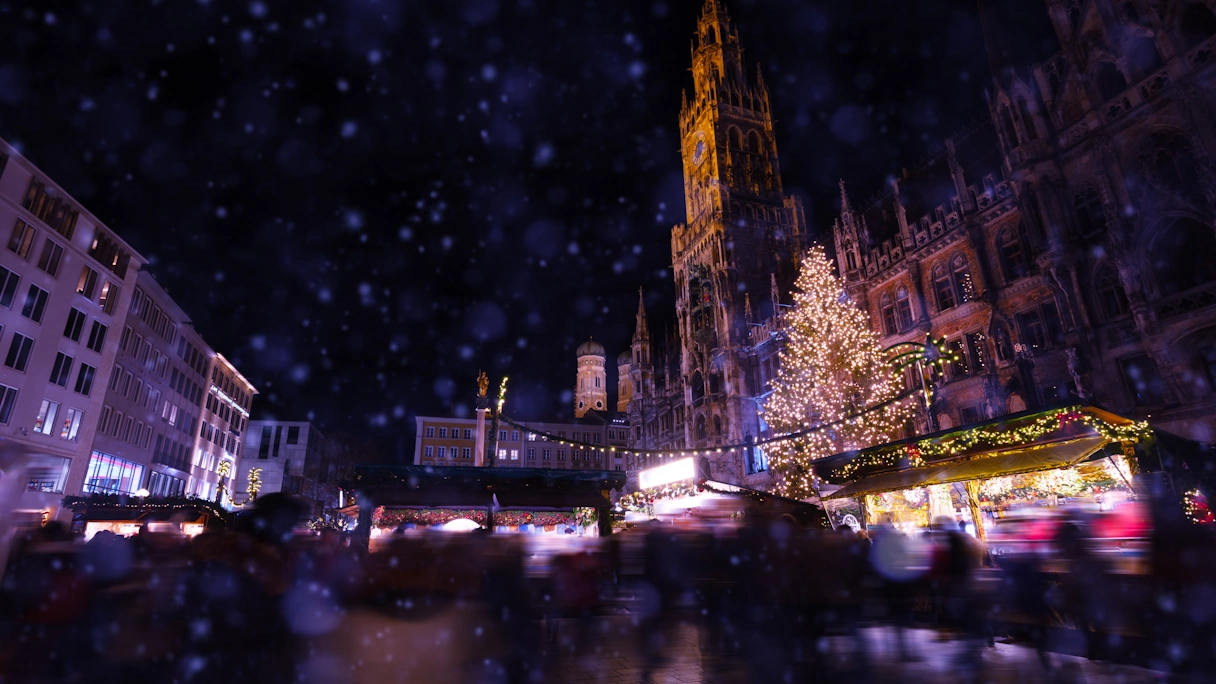 Der Christkindlmarkt am Marienplatz von einer tieferen Persepektive. Das Rathaus ist beleuchten, sowie die Buden und der große Weihnachtsbaum