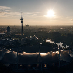 Blick auf den Olympiapark mit Stadion und Turm bei Sonnenuntergang