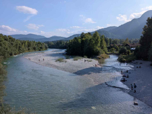 Blick auf die Isar in Bayern bei gutem Wetter. Im Hintergrund sieht man die bayerischen Alpen