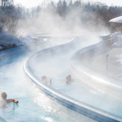 Der Strömungskanal der Chiemgau Thermen in Bad Endorf. Es ist Winter und einige Leute schwimmen