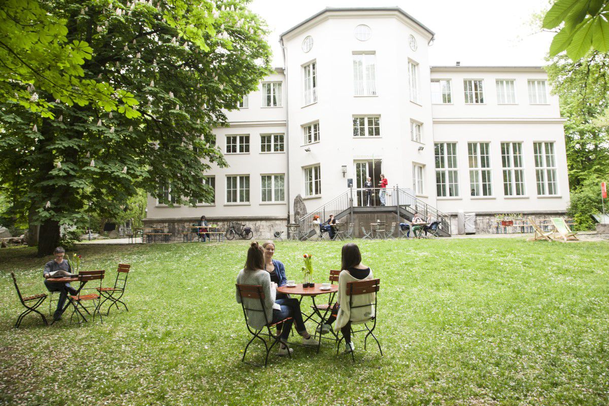 Freier Rasenbreich zum Sitzen mit dem Café Isarlust vor dem Alpines Museum