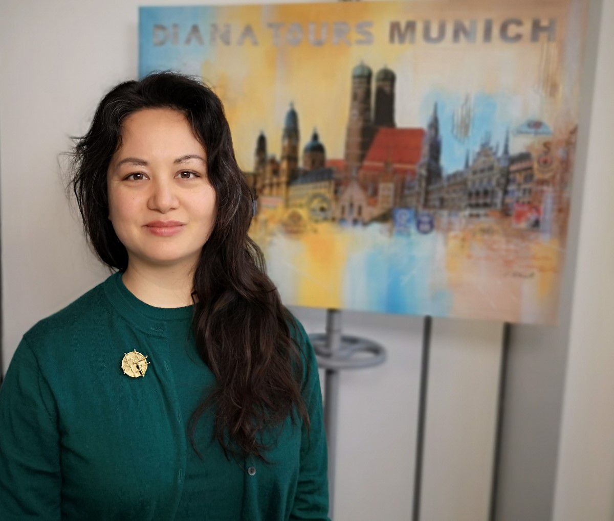 Owner Diana in front of a Munich portrait