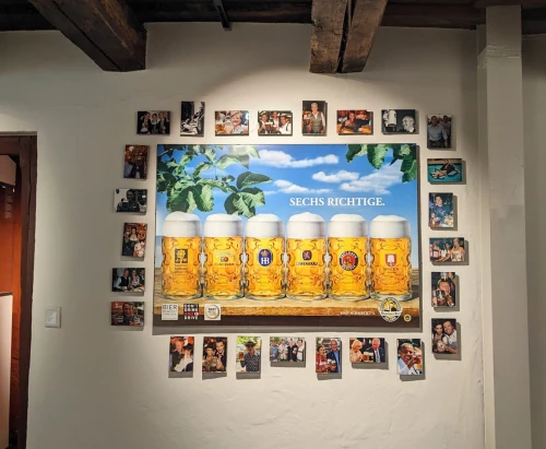 Bier & Oktoberfestmuseum Ausstellung, Bild mit verscheidenen Bierkrügen und kleine Bilder von Stars in Deutschland in Tracht