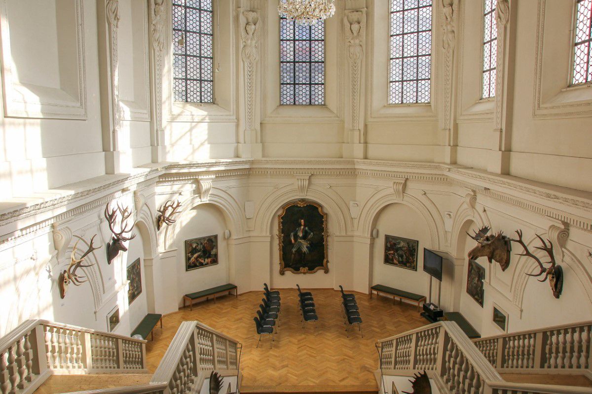 Saal des Jagd- und Fischereimuseums mit Gemälden und Hirschköpfen an den Wänden