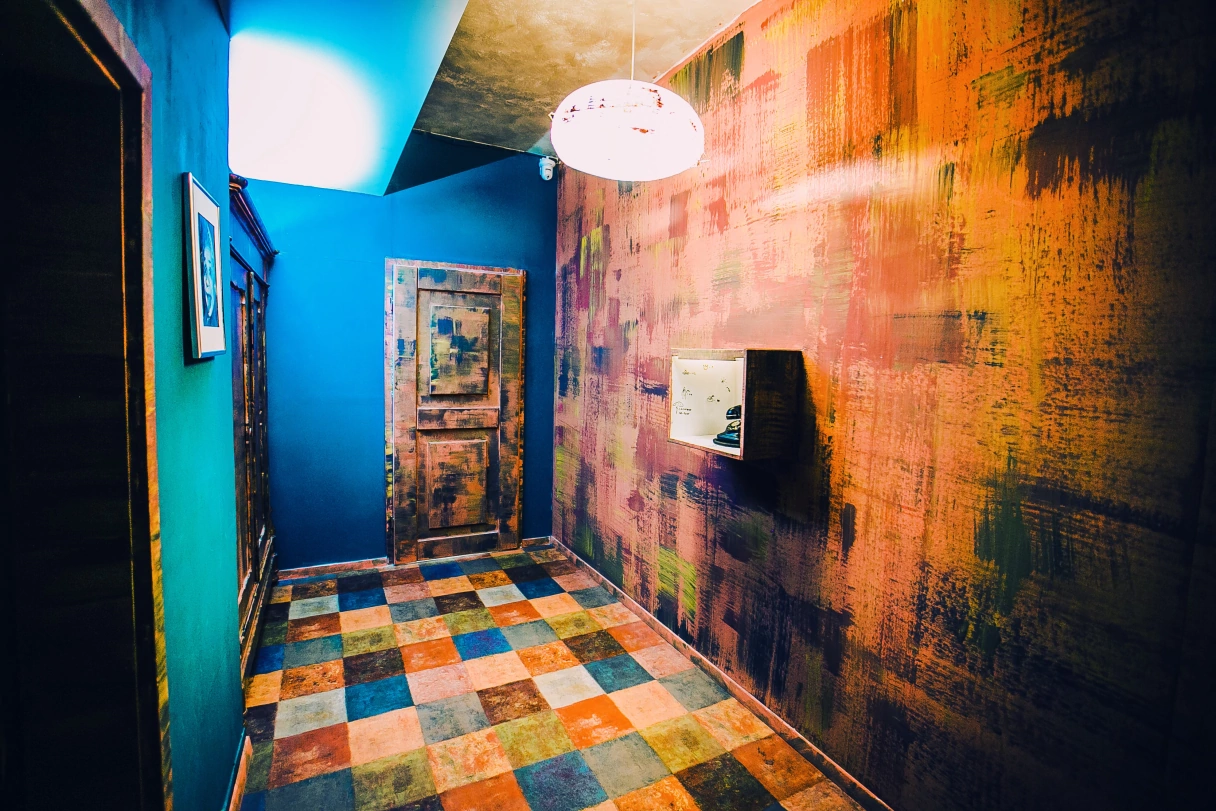 Beispiel Escape Room, leer stehend in unterschiedlichen Farben bemalt mit einer Tür und Lampe