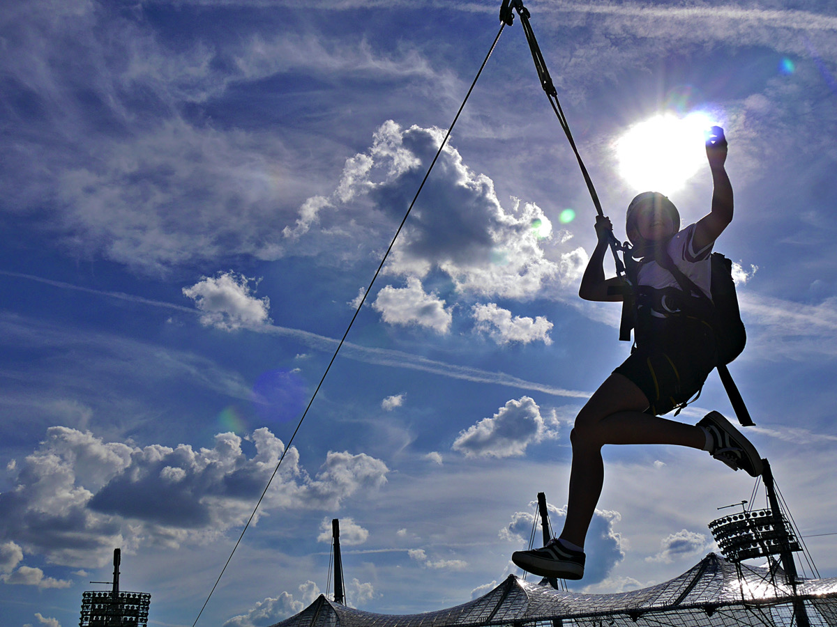 Sprung einer jungen Frau durch das Olympiastadion an einem Seil