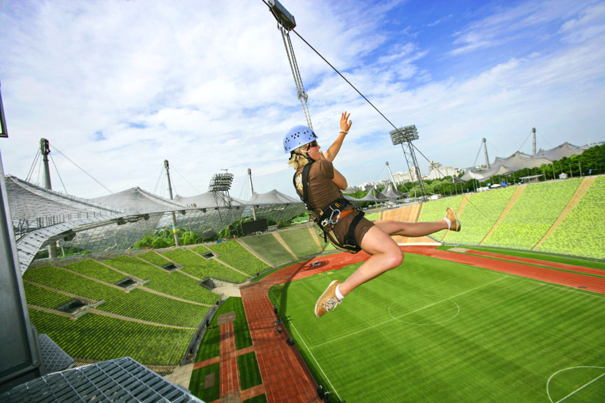 Sprung einer jungen Frau durch das Olympiastadion an einem Seil