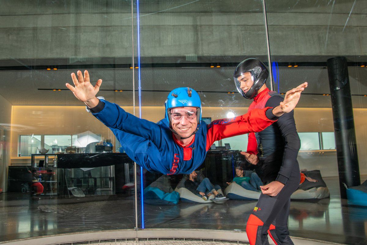 Man floating in wind tunnel with stretched arms and legs