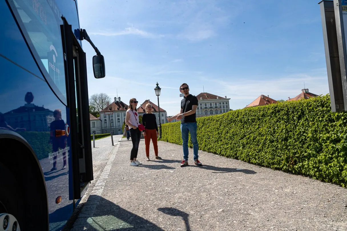 Gray Line Bus in Nymphenburg vor dem Schloss mit Gästen bei Sonnenschein