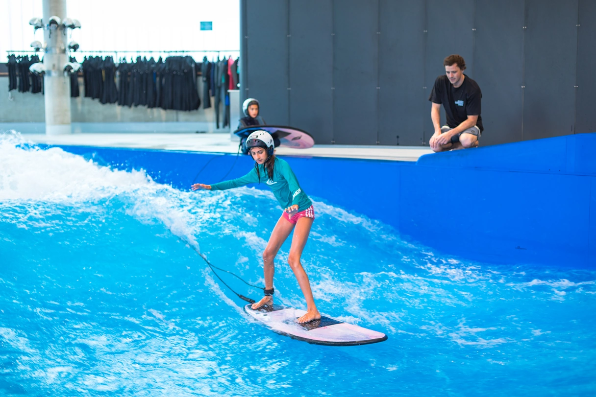 Surfer in the Jochen Schweizer Arena on the water with the trainer by her side