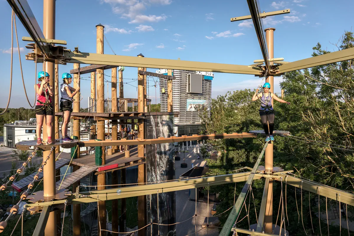 Drei junge Frauen klettern im Jochen Schweizer Outdoor Park