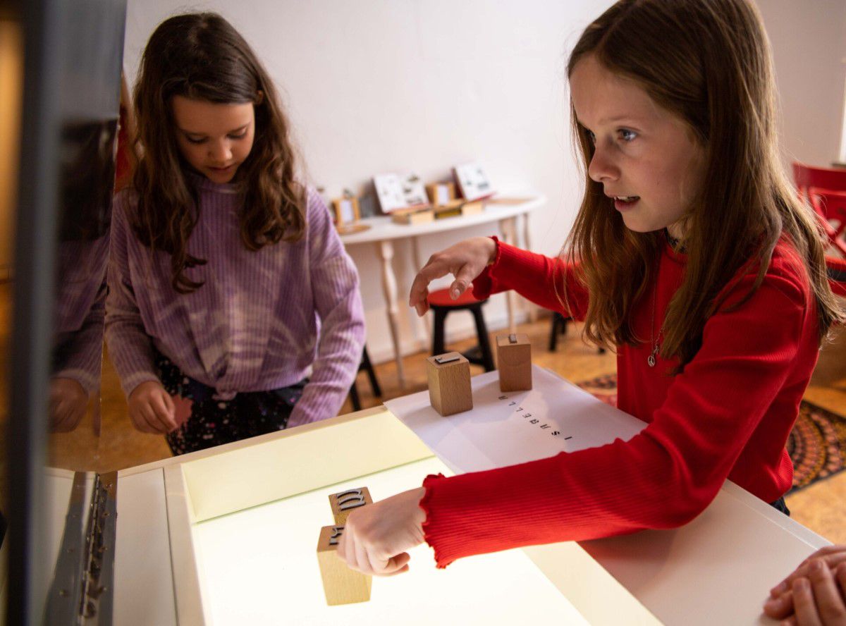 zwei junge Mädchen im Kindermuseum an einer Station zum Ausprobieren mit Bauklötzen