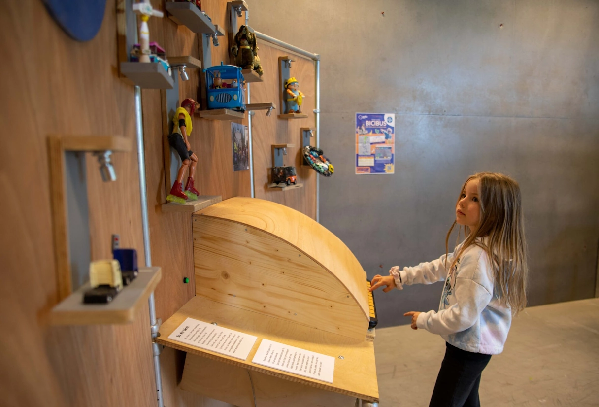 A young girl stands at a hands-on station in the children's museum