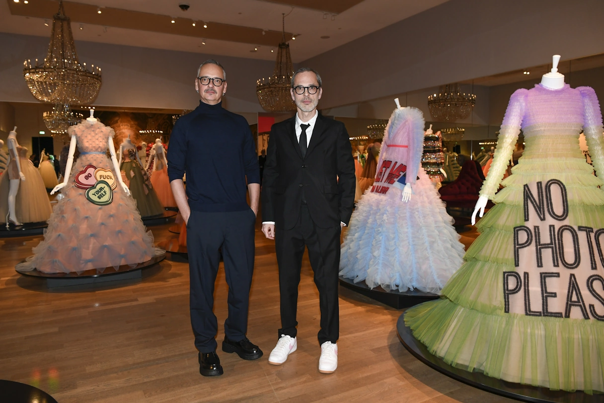 The two artists Viktor and Rolf stand between mannequins wearing colorful and bulky dresses with lots of tulle and statements like 