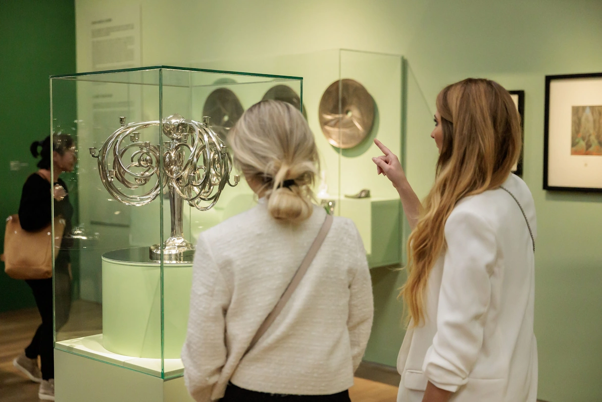 Two visitors to the Kunsthalle Munich at the exhibition Jugendstil Made in Munich. They are looking at a large silver candlestick