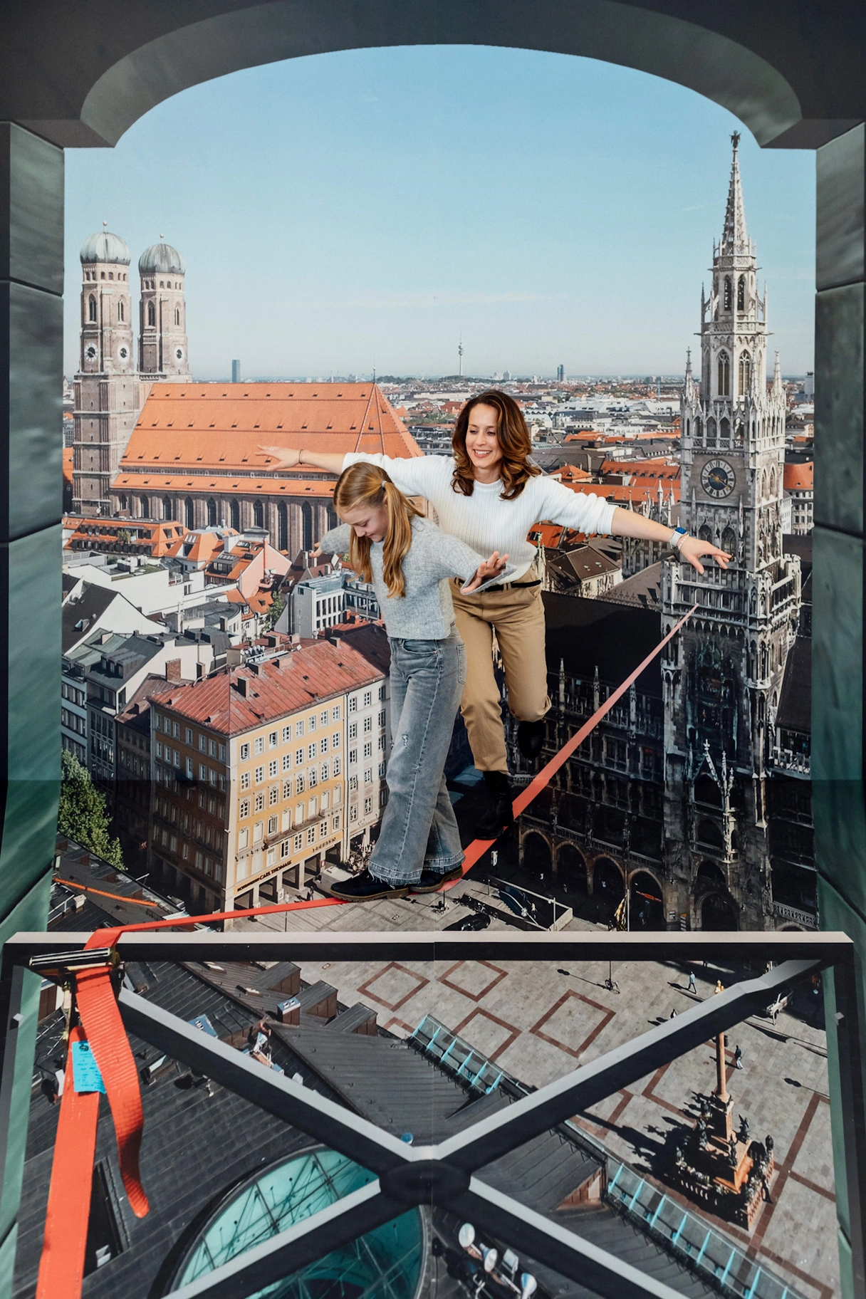 Foto Illusion, Mutter und Tochter balancieren über den Marienplatz