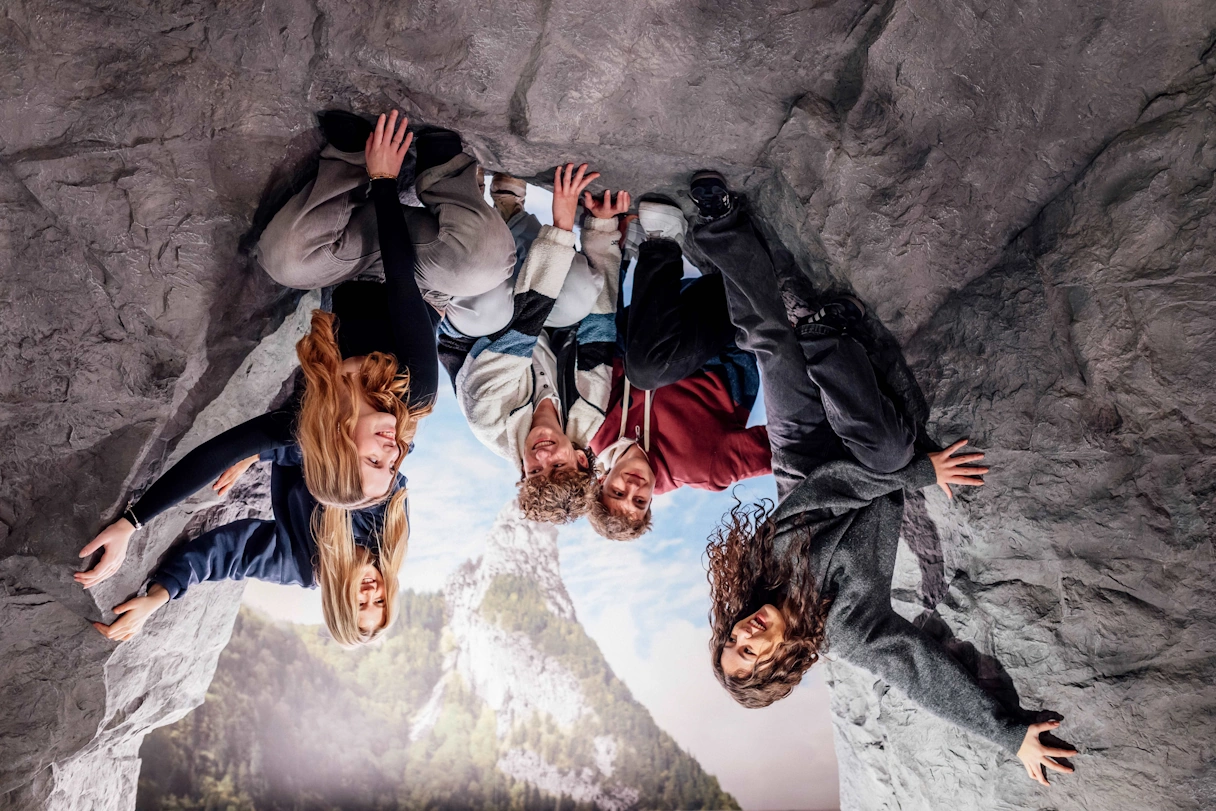 Eine Gruppe Teenager in einem Upside Down Foto mit dem Motiv eines Fels.
