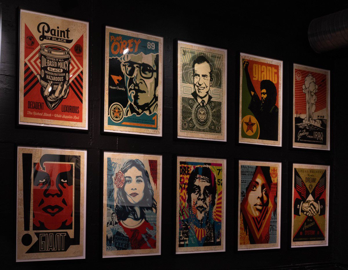 Ausstellungsbereich im MUCA mit mehreren Gemälden von Gesichtern an schwarzen Wänden