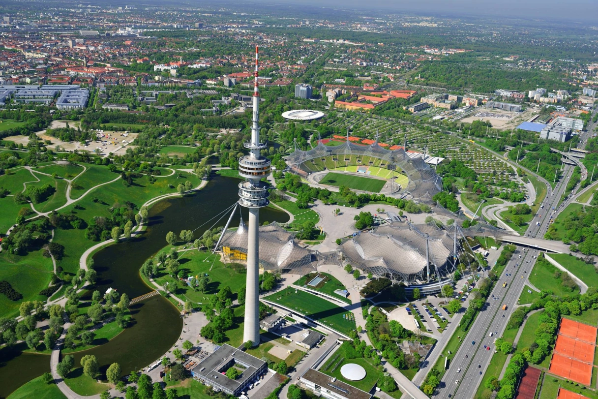 Olympiapark von oben fotografiert mit Blick auf die Grünflächen, den Olympiaturm und Stadion