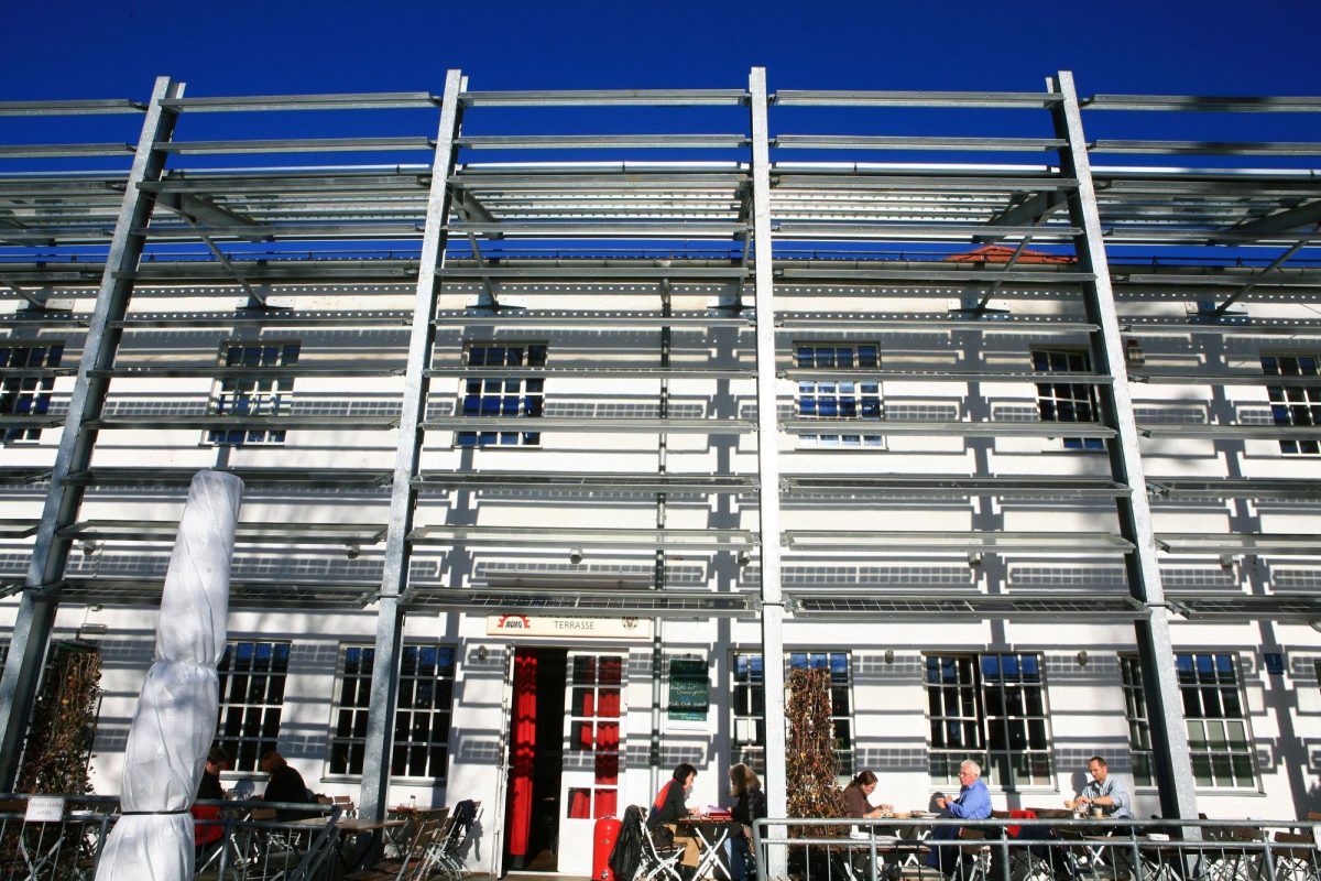 Die Außenfassade der Pasinger Fabrik bei Tageslicht mit Solaranlagen