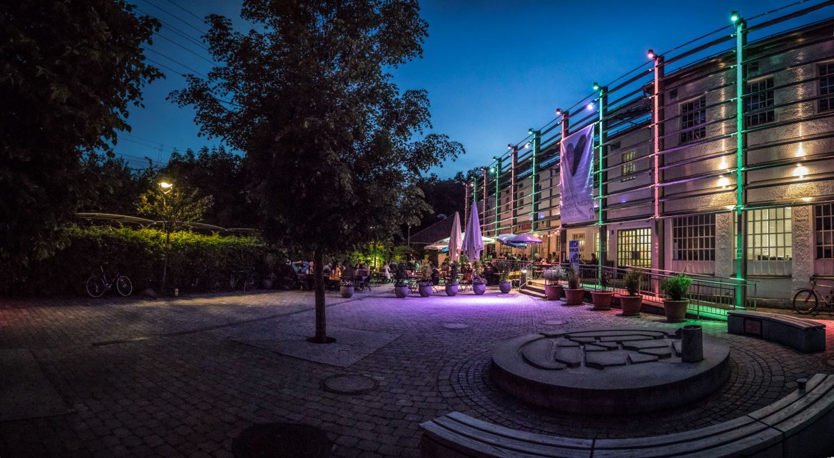 Paringer factory illuminated from the outside with colorful lights in the evening