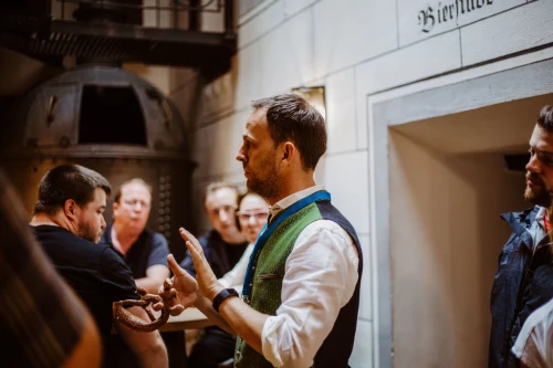 Tourguide in bayerischer Tracht mit einer Brezel in der Hand während einer kulinarischen Tour