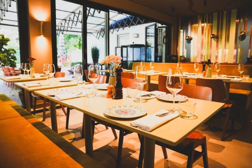Restaurant Riviera: der große Innenbereich. Die Tische sind alle gedeckt mit Tellern, Besteck und Weingläsern. Gäste sieht man keine auf dem Foto