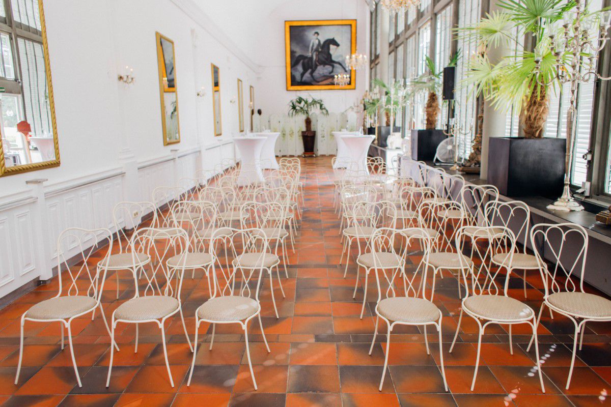 Schlosscafé im Palmenhaus, Blick in den Innenbereich, weiße Stühle stehen aufgereiht