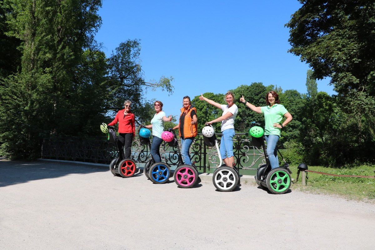 Seg to rent München, Touristengruppe steht auf Segways und alle strecken den Daumen in die Höhe