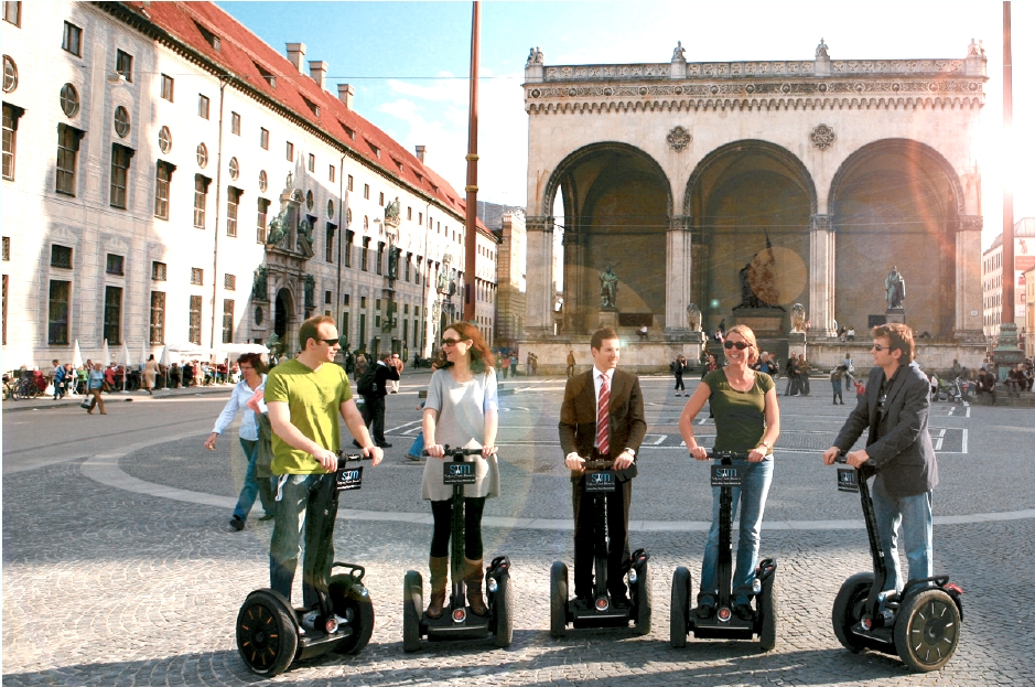 Segway Tour Munich, Gruppe Touristen steht auf Segways auf dem Odeonsplatz vor der Feldherrnhalle