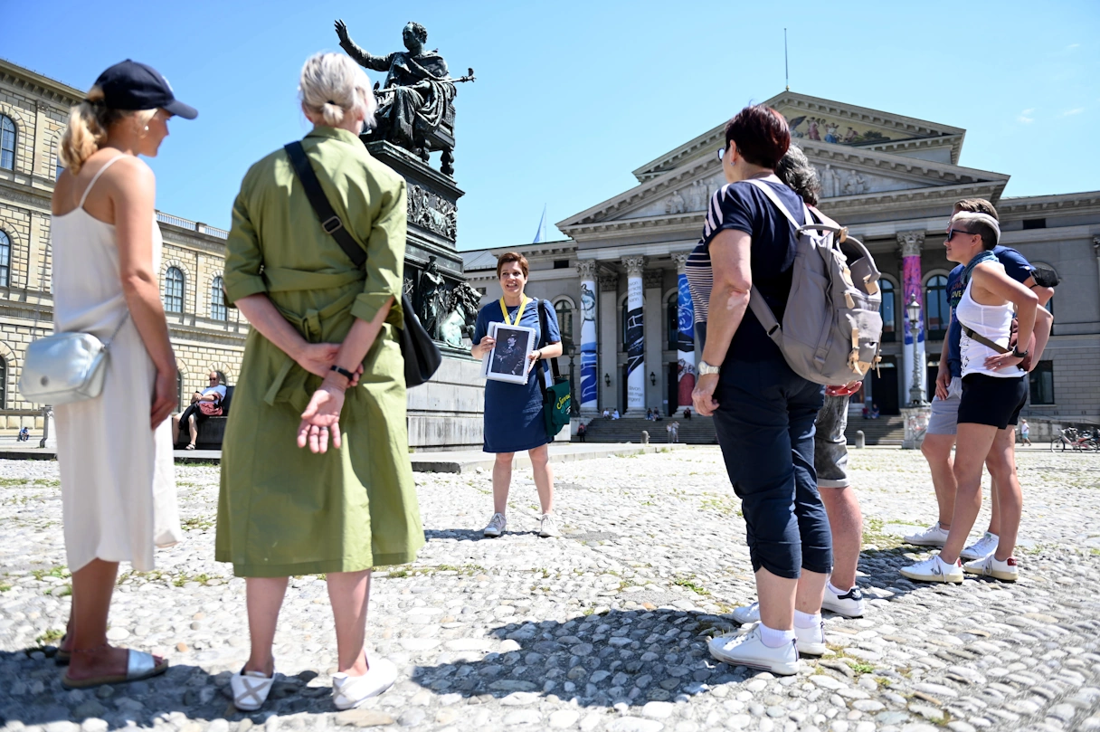 Stadtführung mit Servus Bavaria Tours, eine Gruppe steht mit der Stadtführerin Synthia vor dem Opern Haus