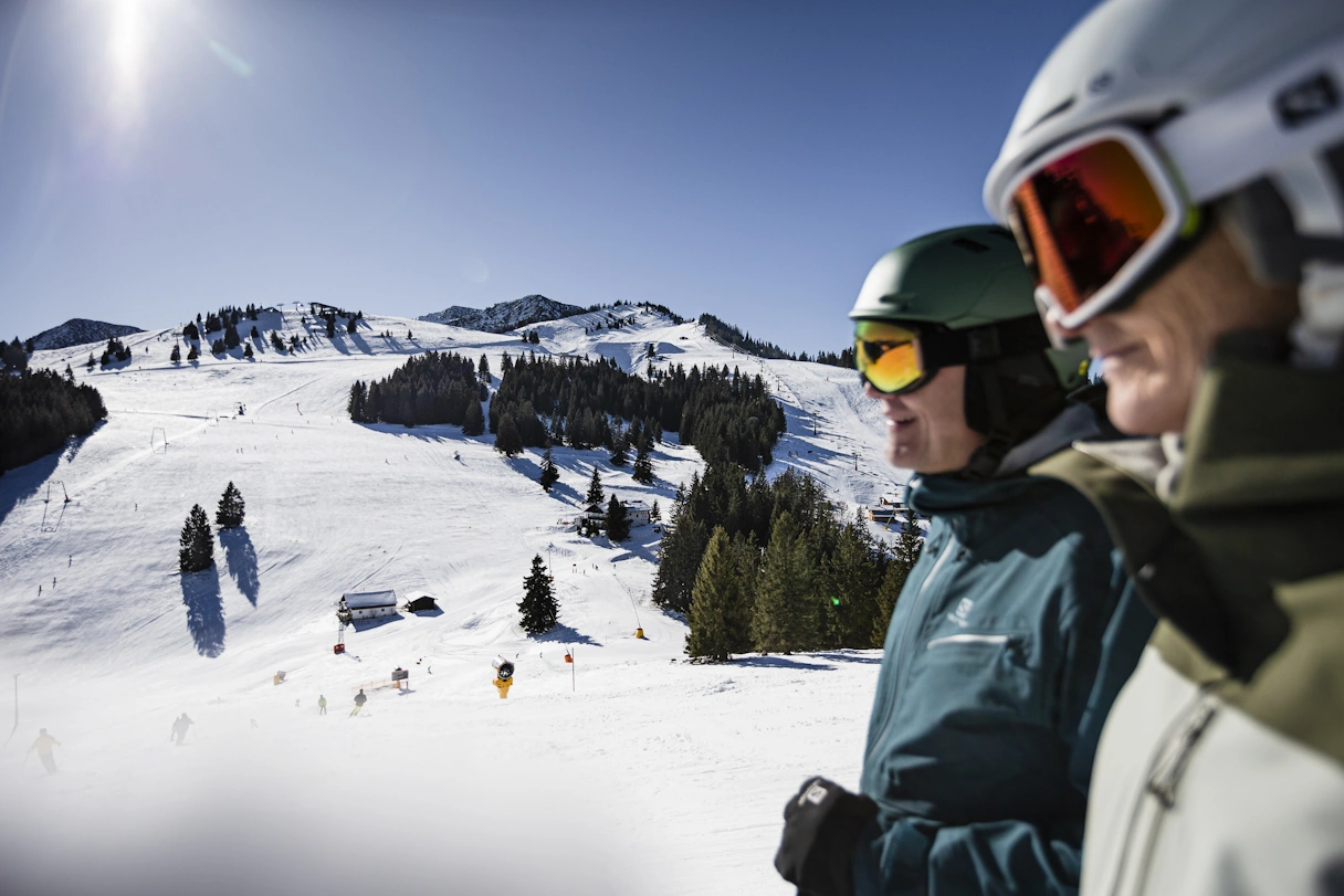 Zwei Skifahrer in Sudelfeld auf dem Berg bei Sonnenschein