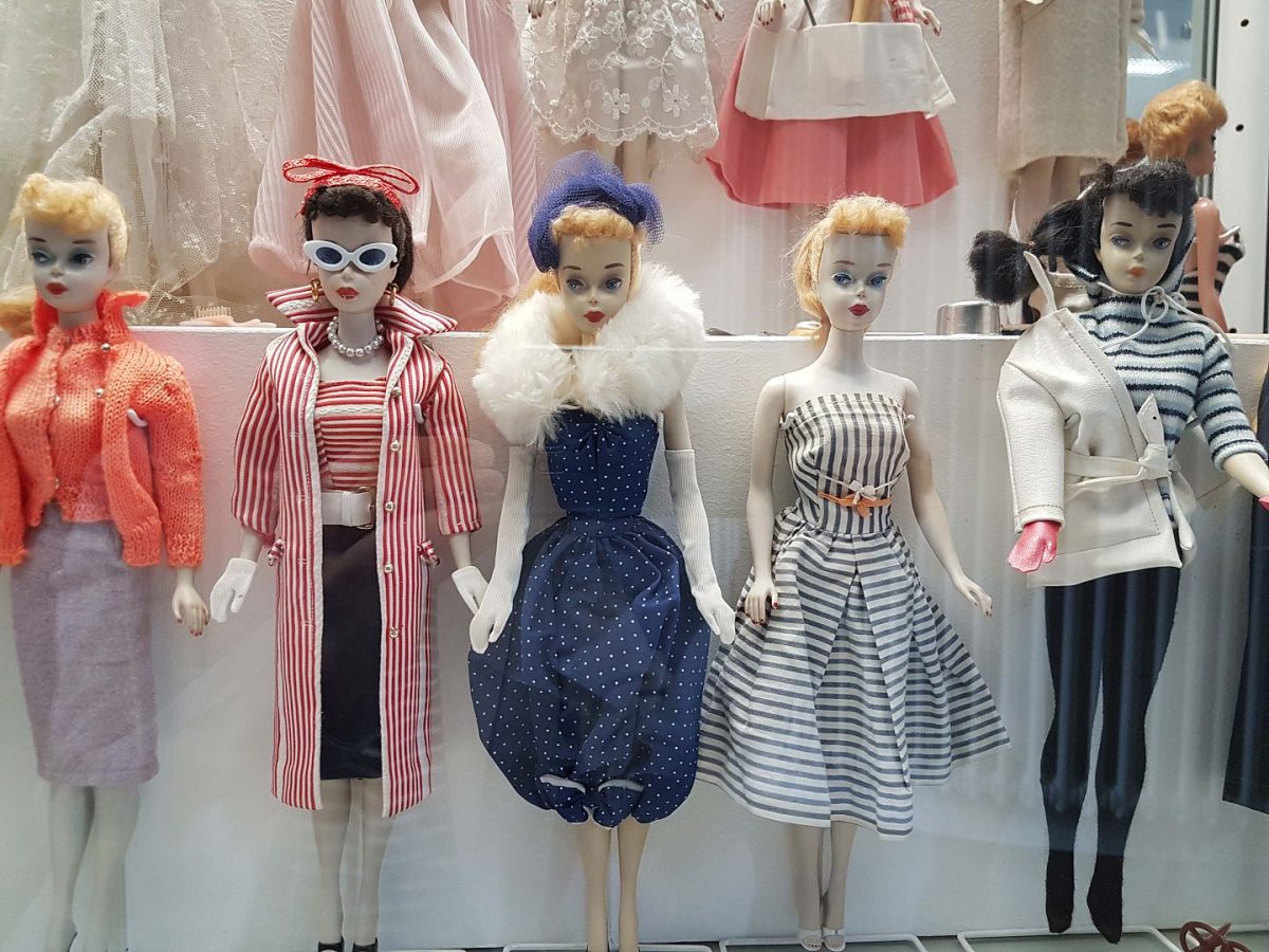 Aufgestellte Barbiepuppen aus vergangenen Jahrzehnten mit bunter Kleidung
