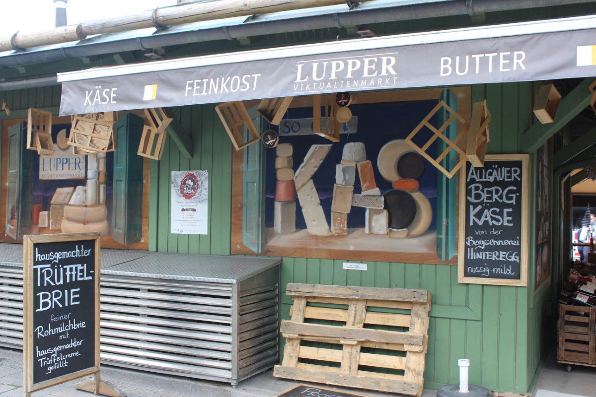 Feinkostladen LUPPER von Außen mit Schildern zu Angeboten und Holzpaletten