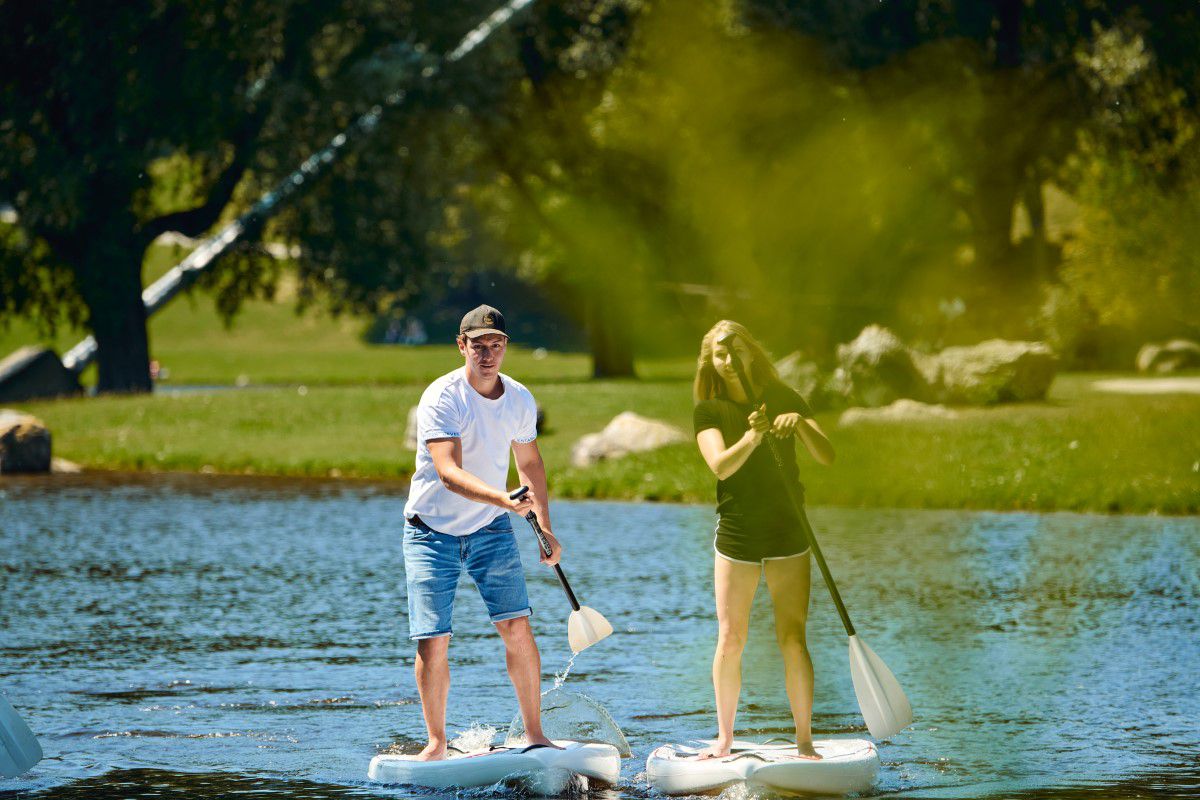 Zwei Personen stehen auf einem Stand Up Paddle auf dem Olympiasee