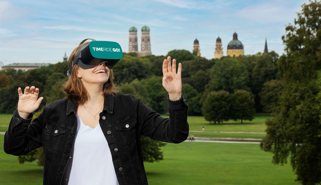 Junge Frau mit der TimeRide GO! VR Brille im Englischen Garten