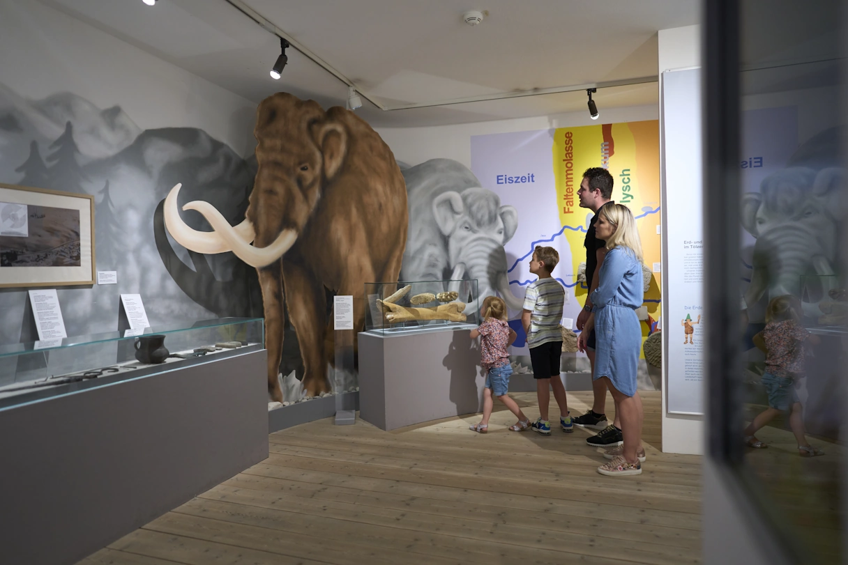 Familie besucht das Tölzer Stadtmuseum. Die Ausstellung zeigt Dinge aus der Eiszeit.