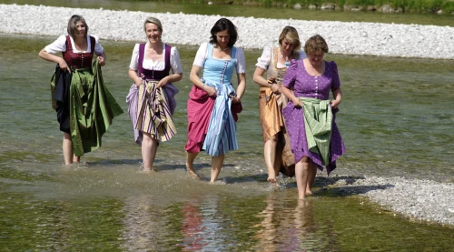 Die 5 Tölzer Stadtversucherinnen im Dirndl gekleidet in der Isar stehend.