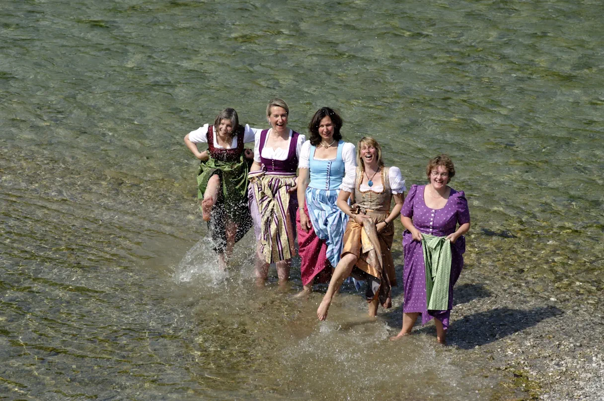 Die 5 Tölzer Stadtversucherinnen im Dirndl gekleidet in der Isar stehend.