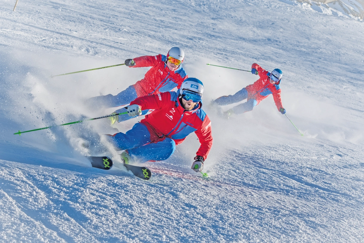 Three skiers skiing down a steep slope in Sudelfeld.