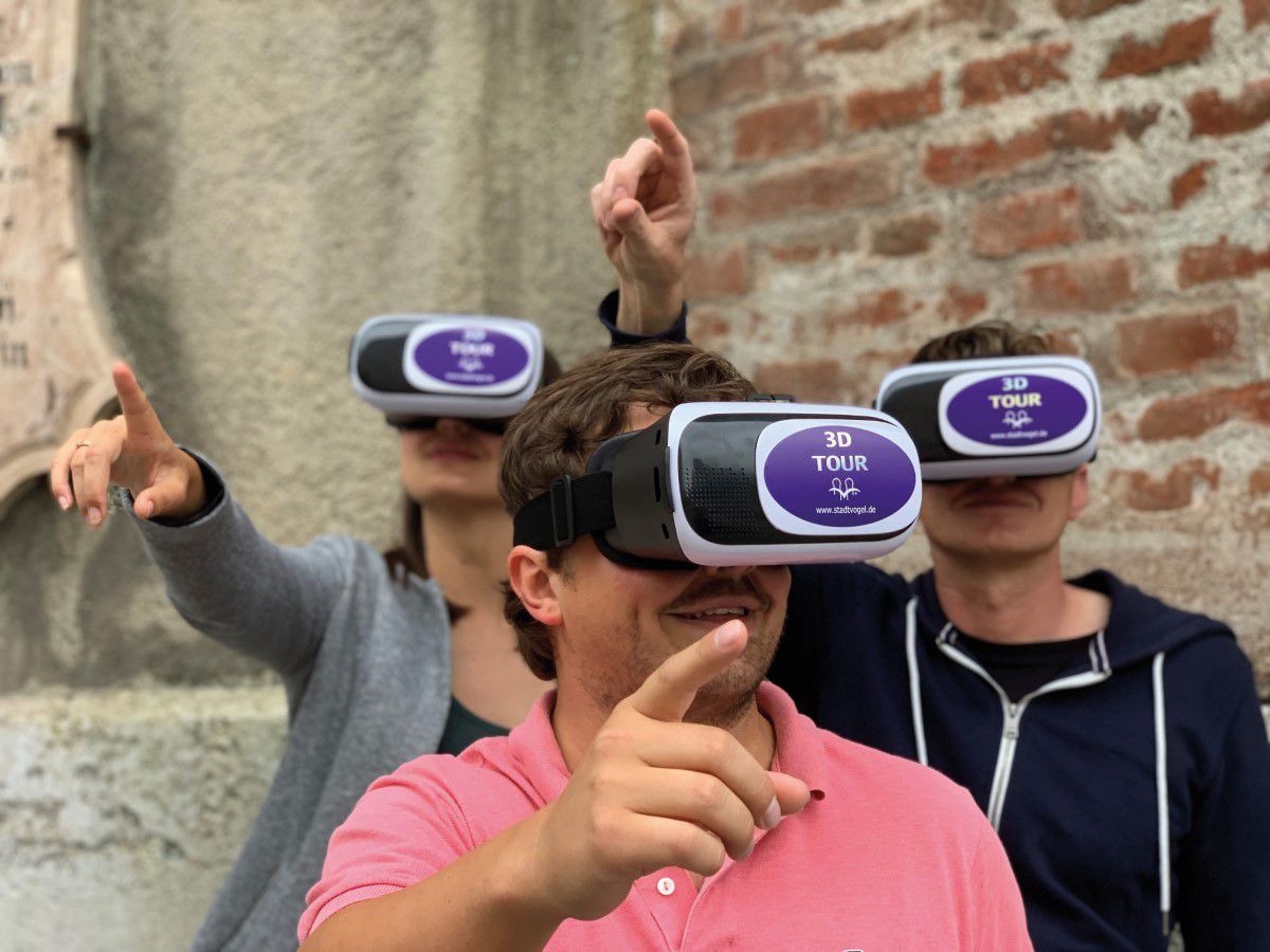3D Tour, Stadtfürhung mit Virtual Reality Brillen, Touristen haben VR Brillen auf und zeigen mit ihren Fingern alle in die gleiche Richtung