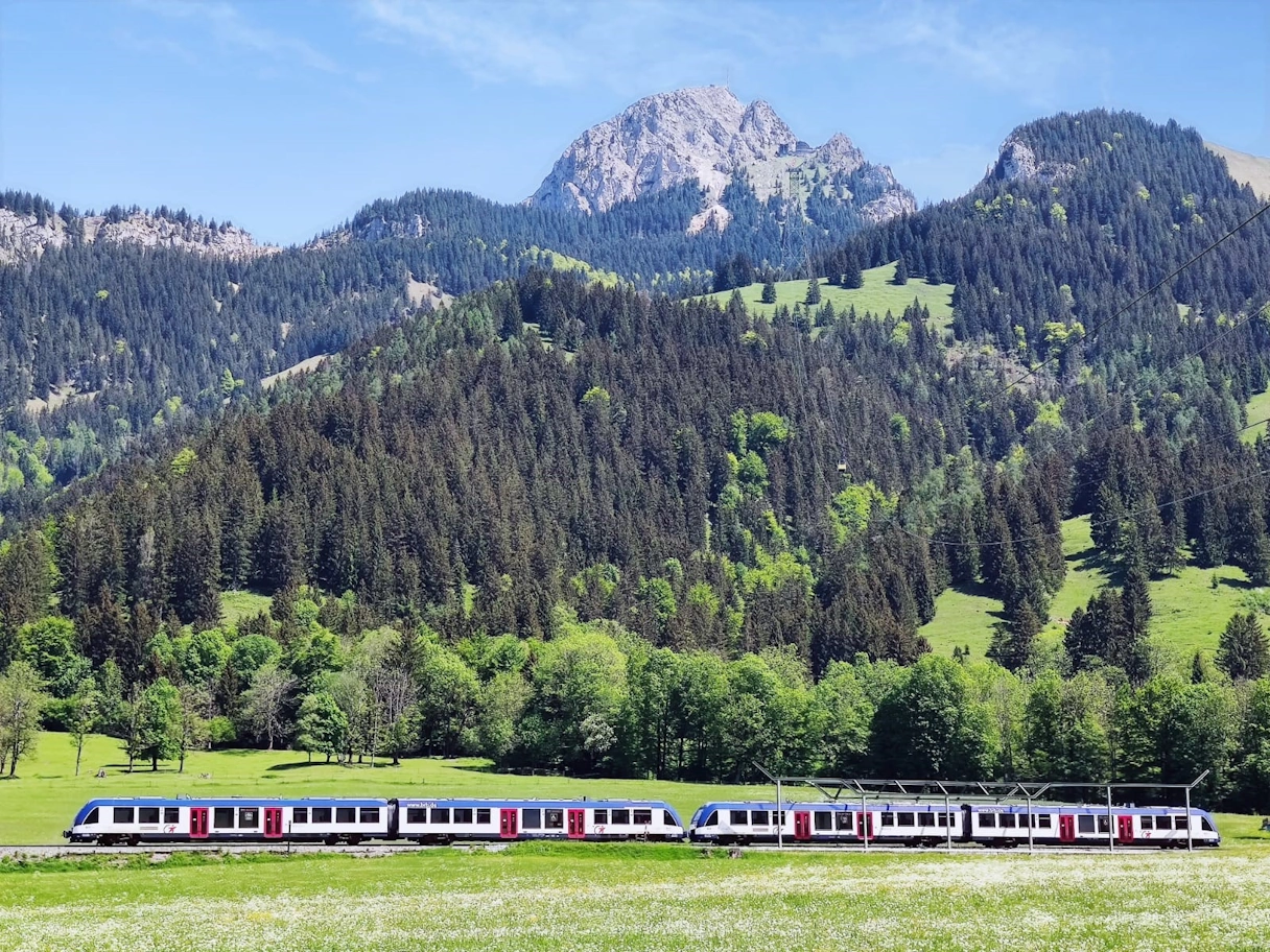 Die Bayerische Regiobahn fährt bei wolkenfreiem Himmel am Wendelstein vorbei